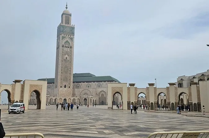The minaret of the Hassan II Mosque above the arched gateways of its esplanade
